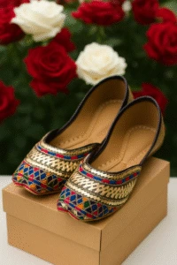 Multicolor embroidered khussa juttis for women – traditional handcrafted shoes with gold, blue, red, and green patterns, displayed on box with rose floral background, ideal for festive and ethnic wear