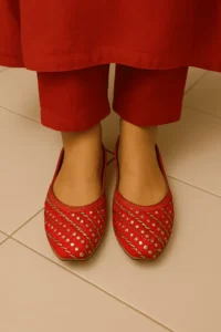 Red traditional khussa shoes with pointed toe and silver embellishments, styled with ethnic red attire—ideal for festive wear, bridal fashion, and handcrafted Pakistani footwear.