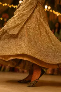Traditional embroidered khussa shoes worn with a golden festive dress in motion, captured at a celebratory event—ideal for bridal fashion, handcrafted ethnic footwear, and luxury Pakistani style.