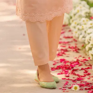 Elegant light green khussa shoes for women styled with peach ethnic wear, perfect for festive occasions and traditional fashion shoots.