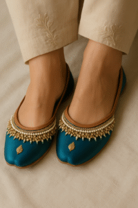 Teal and gold embroidered khussa juttis for women – traditional Indian footwear with intricate embellishments, styled with beige embroidered pants for festive and ethnic fashion