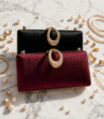 Black and maroon embellished clutch bags styled with pearls and gold jewelry