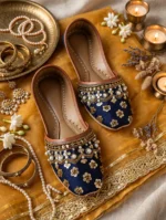 Bridal khussa for women flat lay with gold jewelry, bangles, and candles, luxury Pakistani wedding shoes