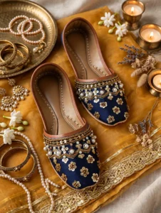 Bridal khussa for women flat lay with gold jewelry, bangles, and candles, luxury Pakistani wedding shoes