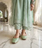 Woman standing in mint green embellished khussa with sequin floral design