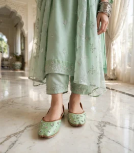 Woman standing in mint green embellished khussa with sequin floral design