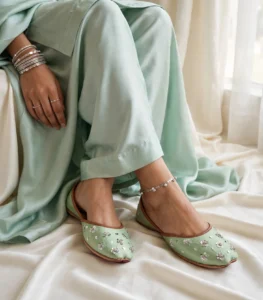 Mint green sequin khussa paired with silver anklet in sitting pose