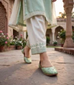 Mint green embellished khussa walking shot in traditional courtyard setting