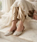 Mirror work bridal khussa flats paired with gold satin pants and pearl bracelet