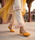 Mustard bridal jutti paired with ivory kurta at Mughal courtyard
