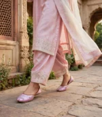 Woman walking in pink bridal khussa at Mughal courtyard