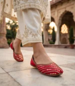 Woman walking in red bridal khussa at Mughal courtyard Pakistan
