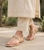 Beige slingback flat sandals paired with a cream chikankari kurta and trousers