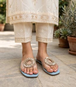 Women's blue crystal chappal worn with cream embroidered kurta and trousers