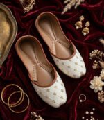 Bridal khussa flat lay with gold jewelry and velvet backdrop