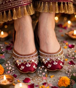Bridal khussa for women at a mehndi setup with candles, flowers and gold tassels