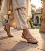 Bridal khussa for women in blush pink with gold embroidery, worn outdoors
