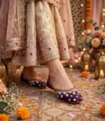 Purple wedding khussa shoes styled with a festive mehndi outfit and floral decor