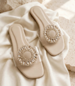 Pair of cream flat chappal with sparkling crystal sunburst design and clear strap on silk fabric