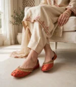 Embroidered khussa for women in rust red worn with a cream embroidered shalwar kameez