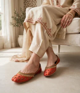 Embroidered khussa for women in rust red worn with a cream embroidered shalwar kameez