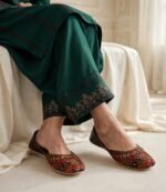 Woman wearing embroidered khussa for women styled with a green embroidered shalwar kameez