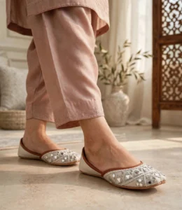 Woman wearing embroidered ivory khussa with pink shalwar indoors