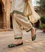 Woman walking in emerald green bridal khussa at heritage courtyard