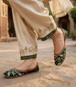 Close up of emerald green bridal khussa with pearl and gold embroidery