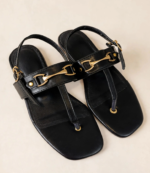 Pair of black flat sandals for women with gold horsebit buckle and adjustable ankle strap