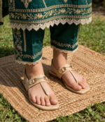 Women's beige T-strap sandals worn with an emerald green embroidered shalwar kameez