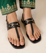 Ladies black flat sandals with gold buckle styled with green gold-embroidered trousers