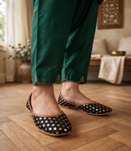 Woman wearing black gold-dot ladies khussa with emerald green shalwar