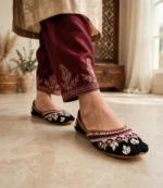 Mirror work khussa women worn with embroidered maroon trousers, walking pose