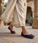 Woman walking in navy blue khussa online Pakistan at heritage haveli