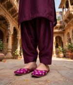 Woman standing in traditional haveli wearing pearl work bridal khussa