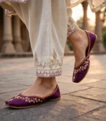 Woman walking in purple bridal khussa online at a heritage location