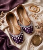 Pair of handmade purple khussa with zari, pearl and mirror work styled with gold bangles