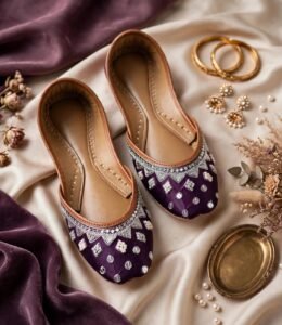 Pair of handmade purple khussa with zari, pearl and mirror work styled with gold bangles
