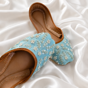 Sky blue embroidered khussa for women on white fabric background