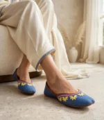 Thin leather sole khussa in blue denim styled with cream trousers and gold anklet