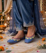 Woman wearing thin sole denim khussa with navy embroidered shalwar and dupatta