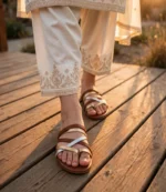 Comfortable ladies flat chappal with metallic straps worn with a cream desi suit