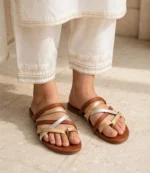 Woman wearing a flat chappal for ladies with a white embroidered shalwar kameez
