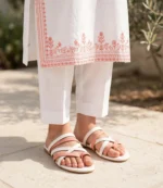 Ladies flat chappal in coral and white worn with a white embroidered kurta and shalwar
