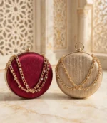 Maroon and golden round clutch bags side by side with gold chains