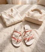 Coral pink and white strappy flat sandals styled with a linen shirt and jute handbag