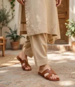 Tan leather H-band slides styled with a beige embroidered shalwar kameez