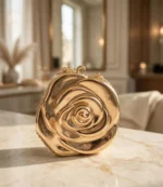 Gold rose shaped clutch bag with chain on a marble table