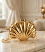 Gold shell clutch bag Pakistan women's party clutch with chain strap on marble table